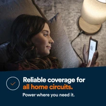 A woman sitting a chair near a lamp holds her cell phone as it charges from a USB outlet on the lamp. Bottom Text Panel reads: Reliable coverage for all home circuits. Power where you need it.